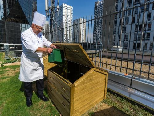 Chef disposes of compostable waste on the roof garden